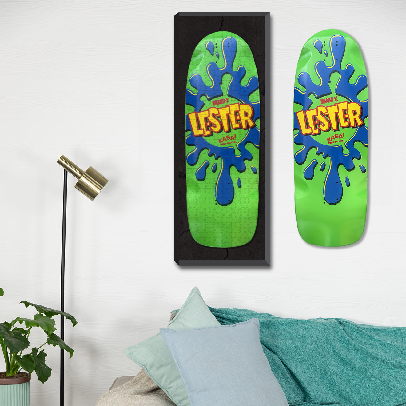 The Brand-X Lester Green and blue skateboard graphic at 10"x30", 500 pieces hanging on a wall next to a Lester Skateboard. 